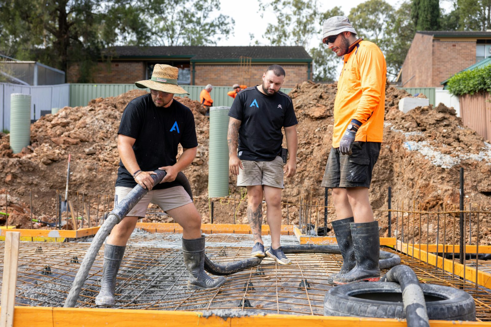 Concrete crew pouring a rebar-reinforced foundation slab